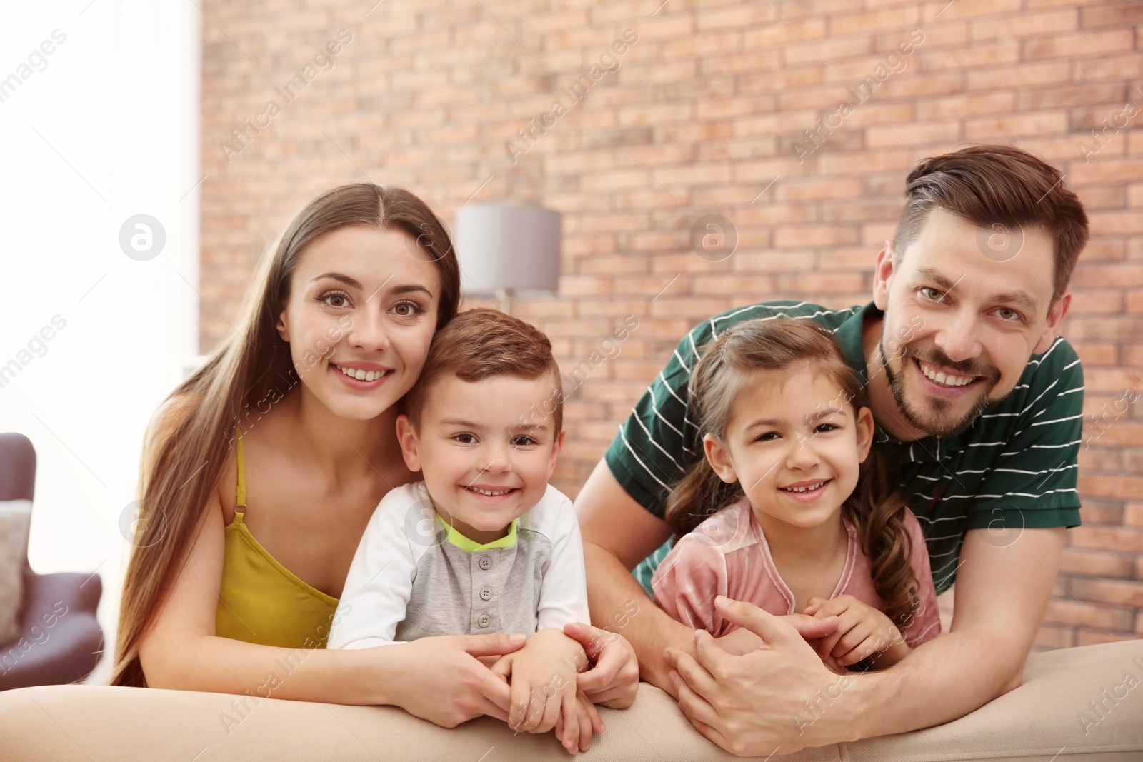 Photo of Happy family with cute children on sofa indoors