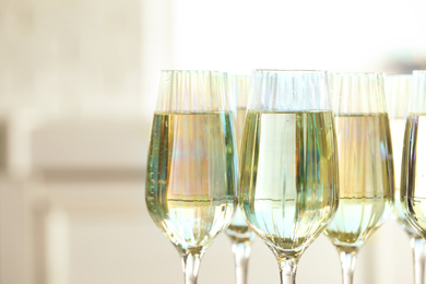 Glasses of champagne on blurred background, closeup view