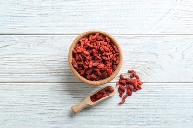 Photo of Flat lay composition with dried goji berries on white wooden table. Healthy superfood