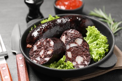 Photo of Tasty blood sausages served on grey table, closeup