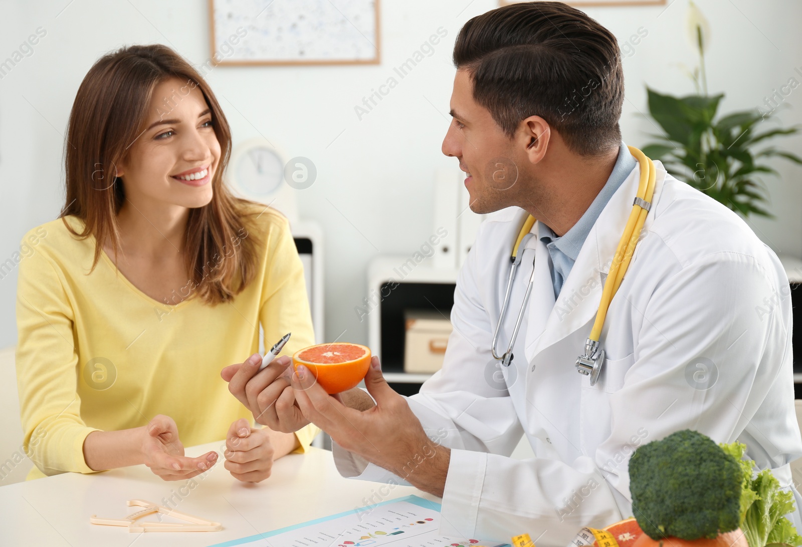 Photo of Nutritionist consulting patient at table in clinic