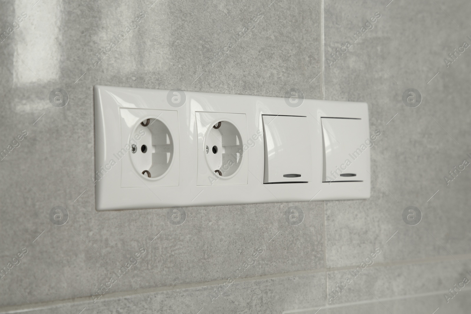 Photo of Light switches and power sockets on wall indoors