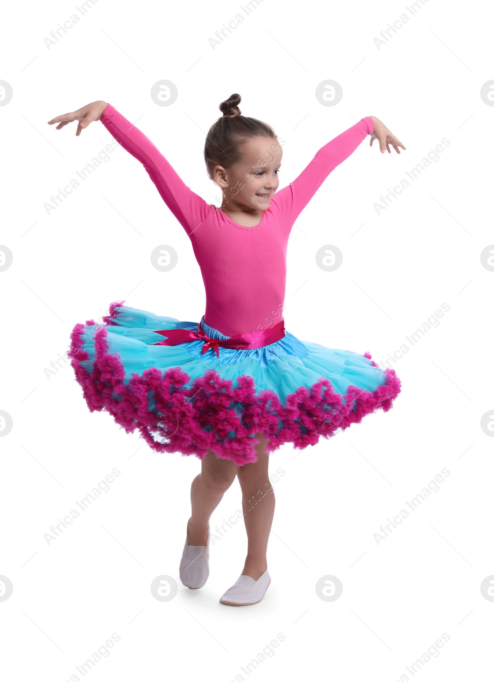 Photo of Cute little girl in costume dancing on white background