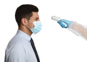Doctor measuring man's temperature on white background, closeup. Prevent spreading of Covid-19
