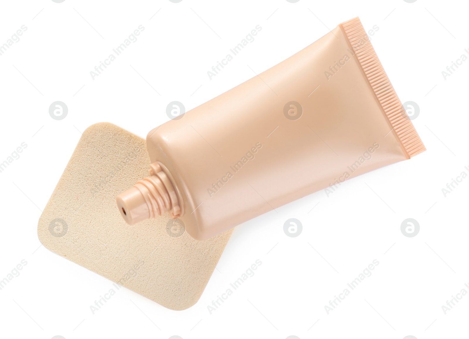 Photo of Tube of skin foundation and sponge isolated on white, top view. Makeup product