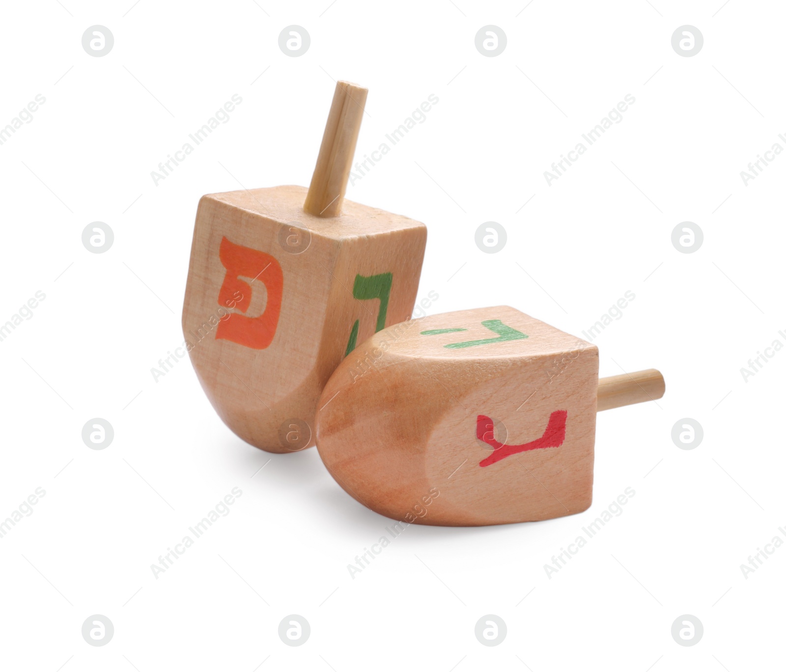 Photo of Wooden dreidels isolated on white. Traditional Hanukkah game