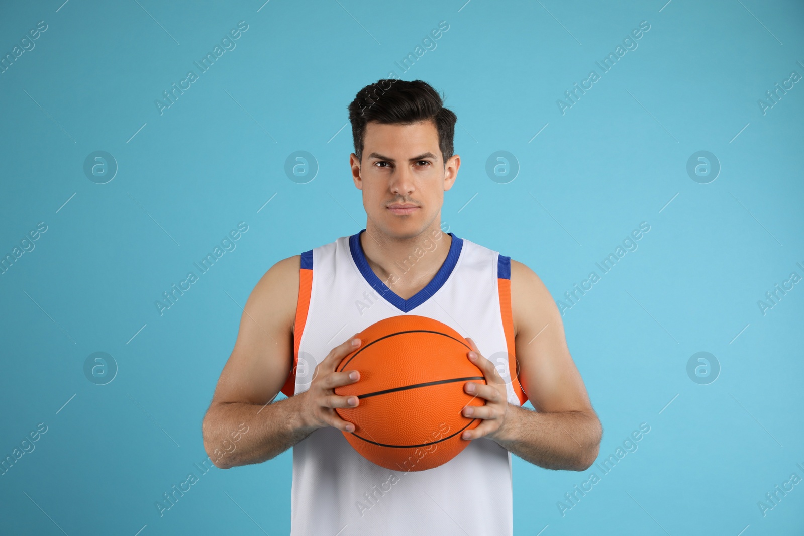 Photo of Basketball player with ball on light blue background