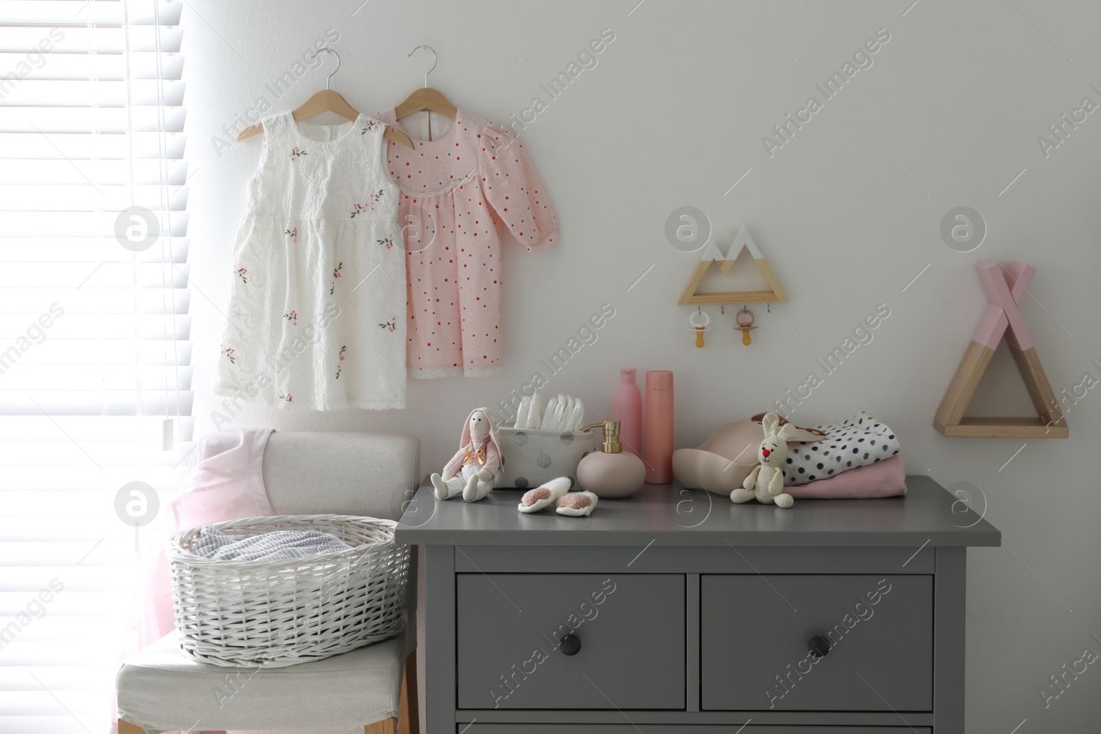 Photo of Stylish chest of drawers and accessories in child room