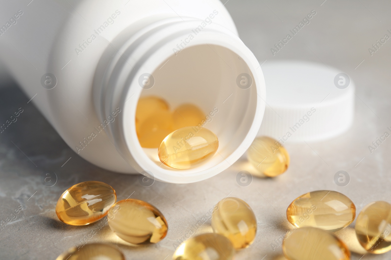 Photo of Bottle with cod liver oil pills on table, closeup