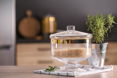 Photo of Jar with rice on wooden table in modern kitchen