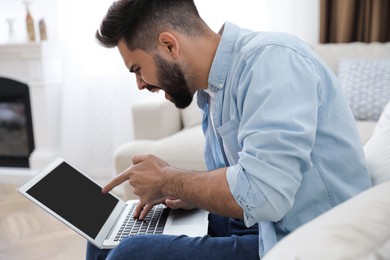 Photo of Emotional young man with laptop at home. Online hate concept