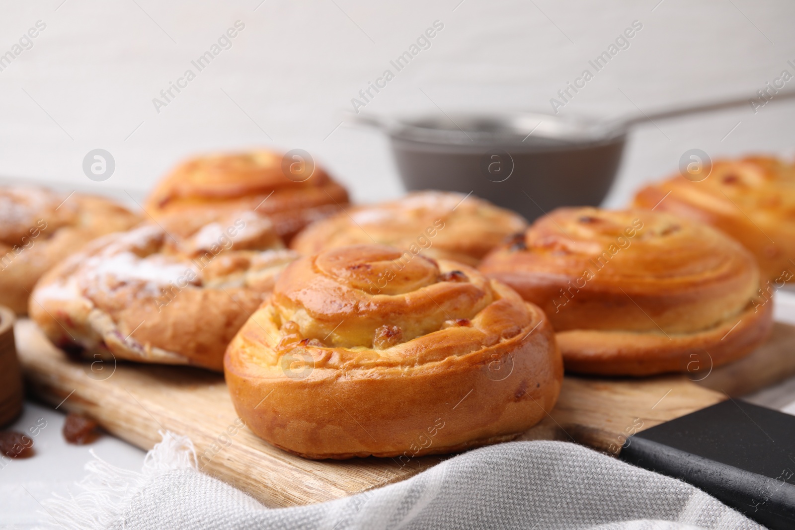 Photo of Delicious rolls with raisins on table, closeup. Sweet buns
