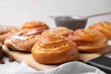 Photo of Delicious rolls with raisins on table, closeup. Sweet buns