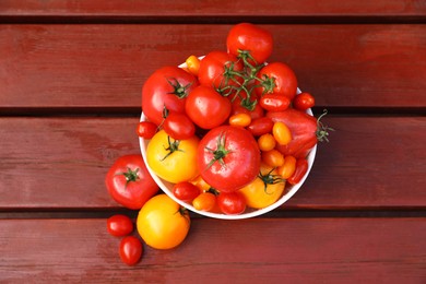 Photo of Bowl with fresh tomatoes on wooden table, top view