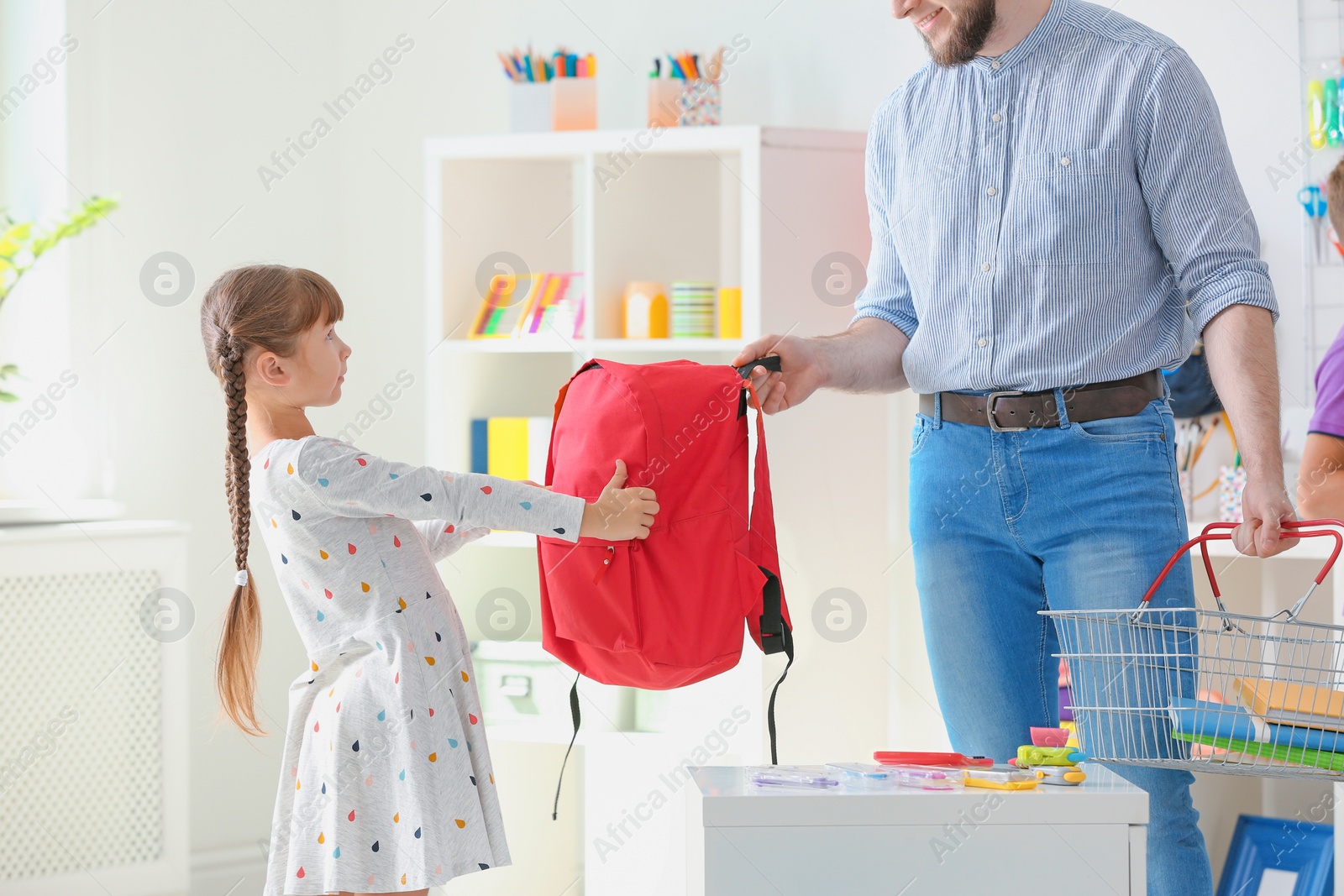 Photo of Little girl with father choosing school stationery in store