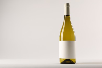 Bottle of tasty wine on white background, space for text