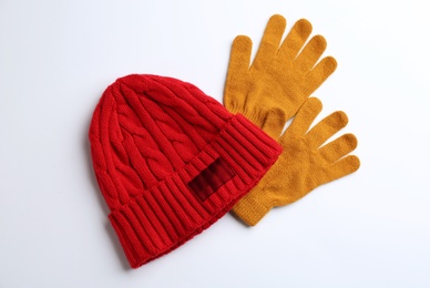 Photo of Woolen gloves and hat on white background, flat lay