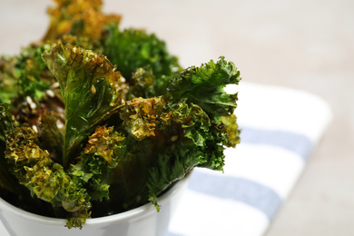 Tasty baked kale chips in bowl, closeup