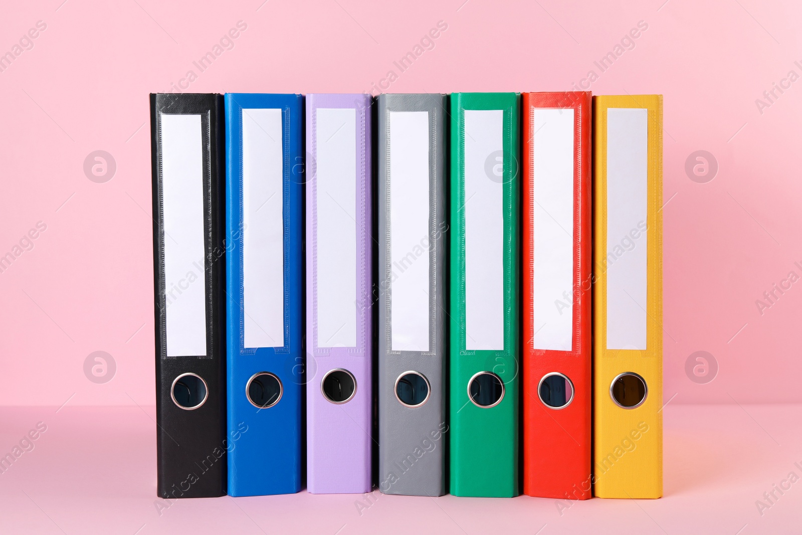 Photo of Many hardcover office folders on pink background