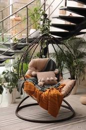 Indoor terrace interior with hanging chair and green plants
