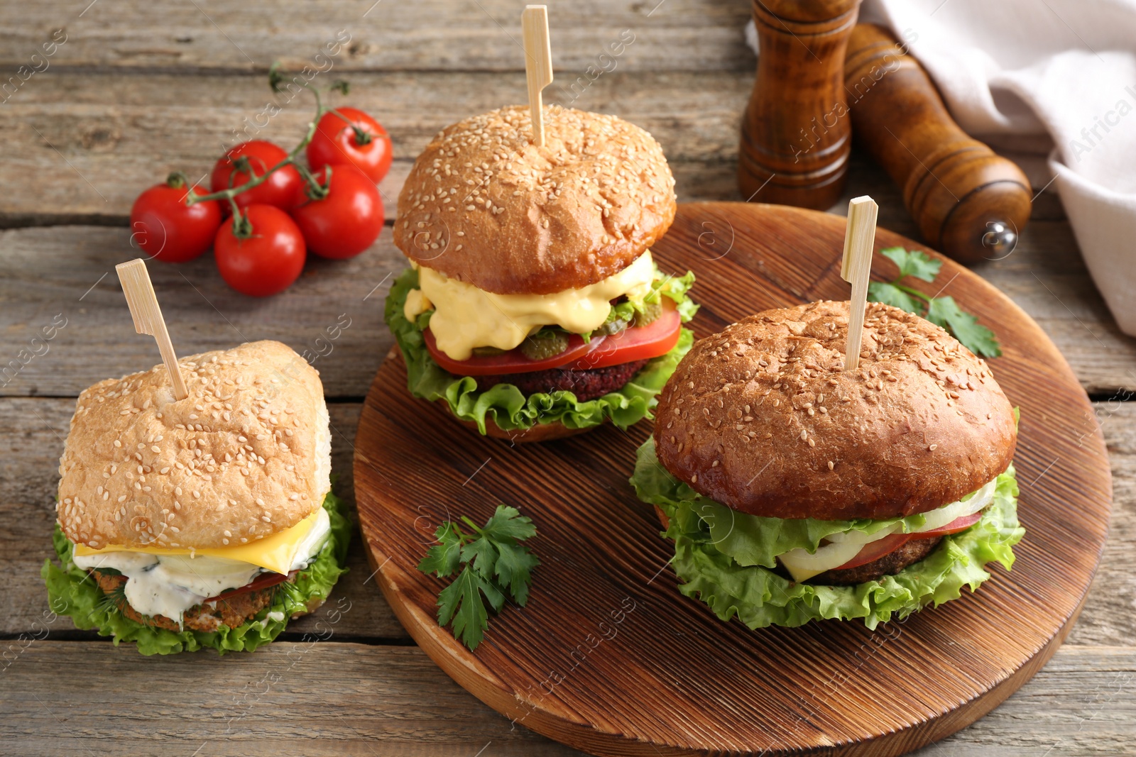 Photo of Delicious vegetarian burgers served on wooden table