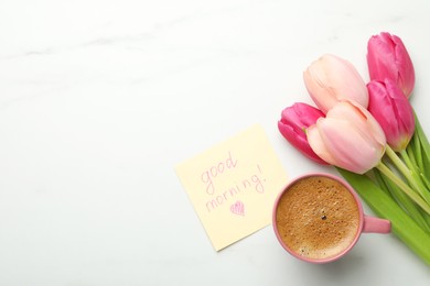 Photo of Cup of aromatic coffee, beautiful pink tulips and Good Morning note on white marble table, flat lay. Space for text