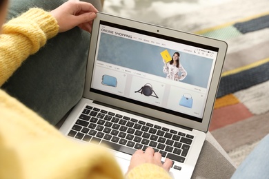 Woman using laptop for online shopping indoors, closeup