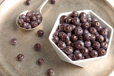 Photo of Bowl with fresh acai berries on tray, closeup