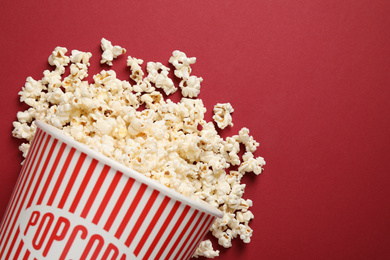 Photo of Delicious popcorn on red background, top view