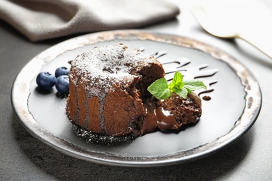 Plate of delicious fresh fondant with hot chocolate and blueberries on table. Lava cake recipe