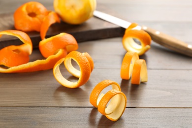 Photo of Spiral orange fruit peels on wooden table