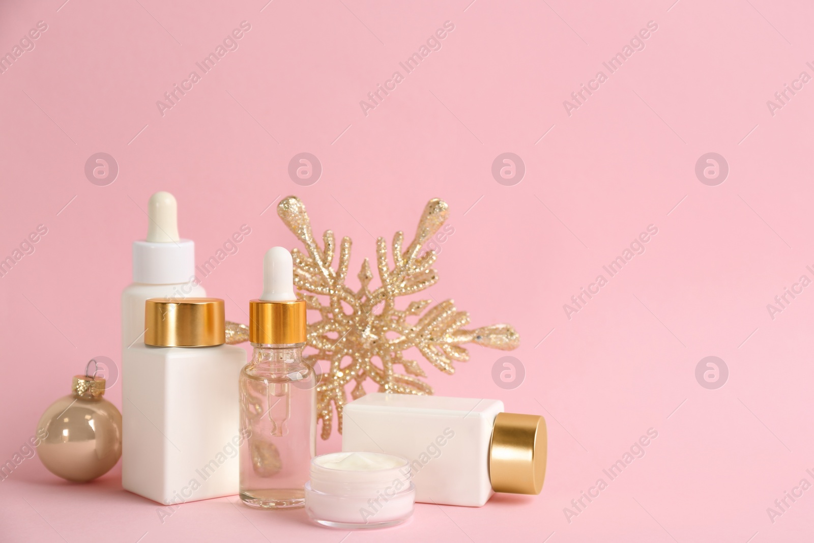 Photo of Beautiful composition with cosmetic products on pink background, space for text. Winter care