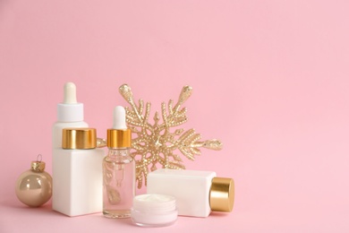 Beautiful composition with cosmetic products on pink background, space for text. Winter care