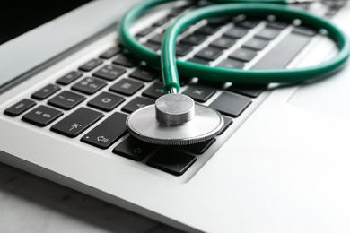 Laptop and stethoscope on table, closeup. Concept of technical support