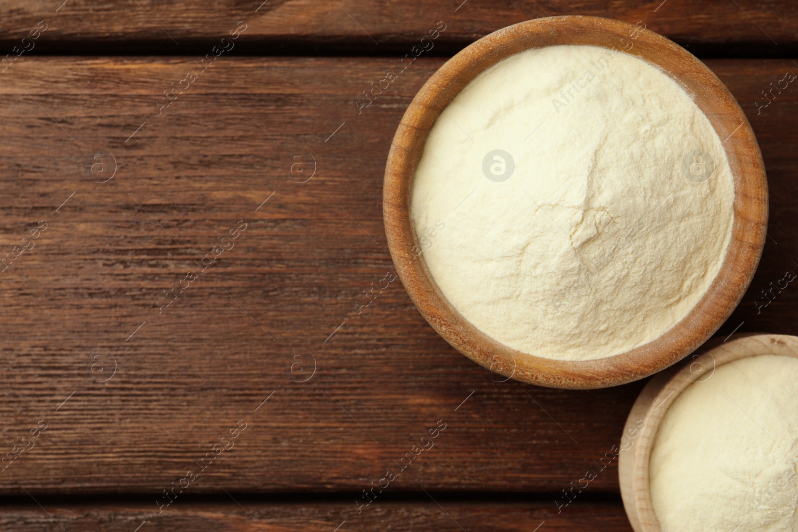 Photo of Bowls of agar-agar powder on wooden table, flat lay. Space for text