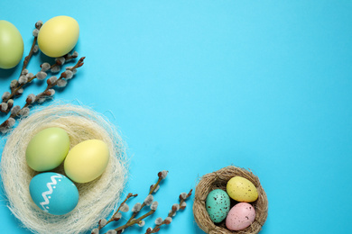 Photo of Flat lay composition with Easter eggs on light blue background. Space for text