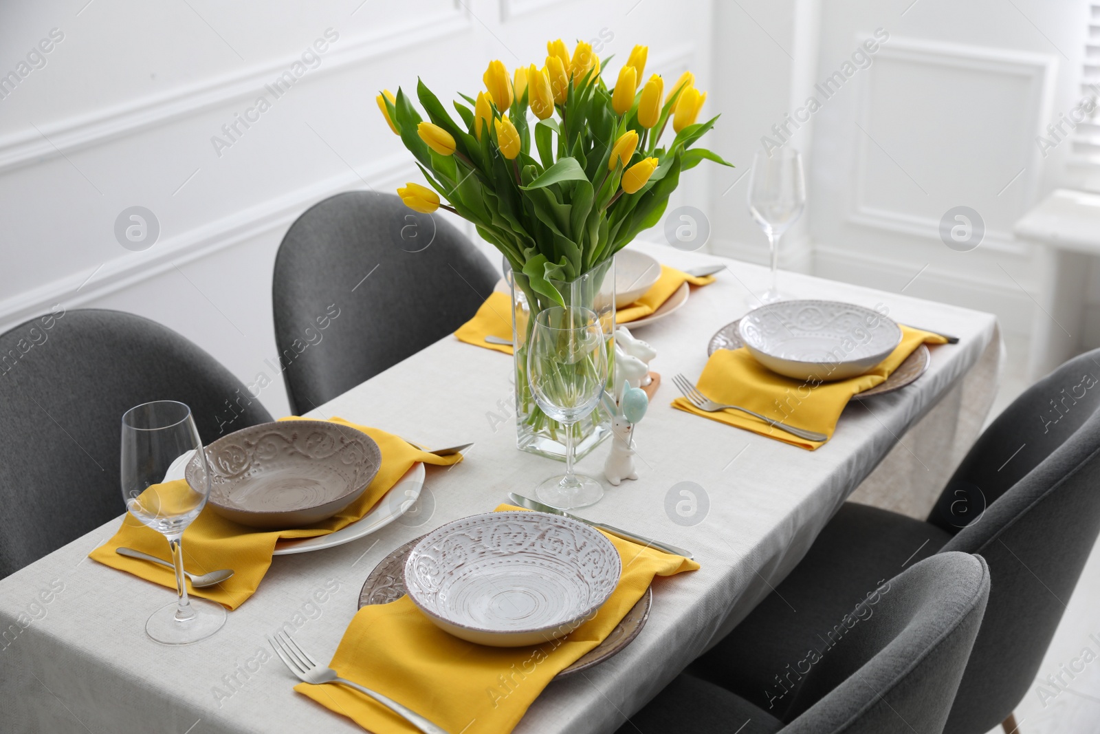 Photo of Beautiful Easter table setting with yellow tulips indoors