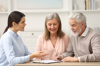 Notary consulting senior couple about Last Will and Testament in office