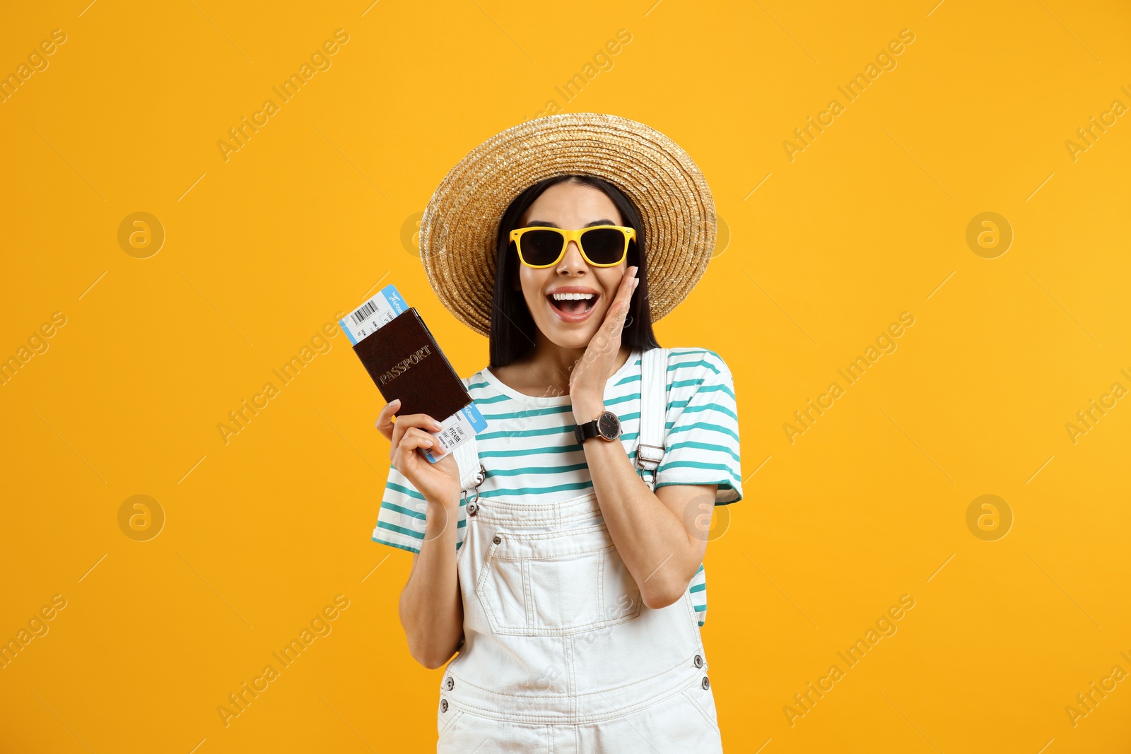 Photo of Happy female tourist with ticket and passport on yellow background