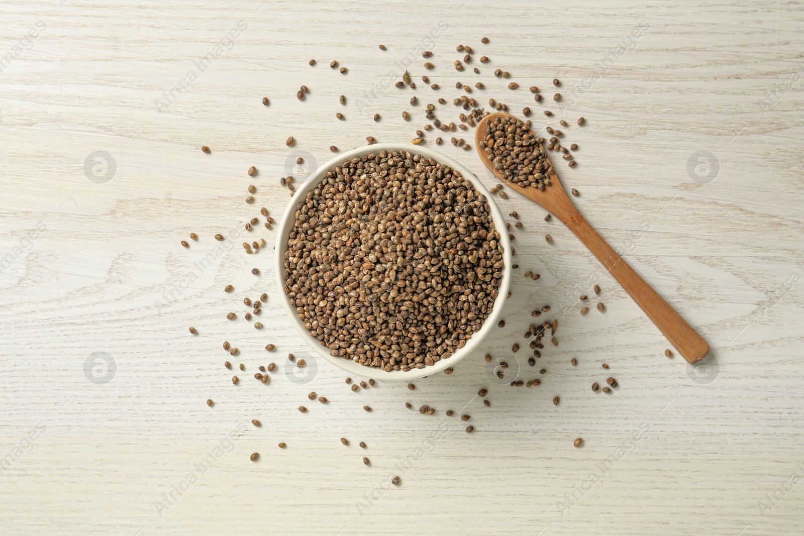 Photo of Ceramic bowl with chia seeds on light wooden table, flat lay. Cooking utensils