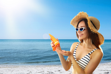 Image of Young woman applying sun protection cream at beach, space for text
