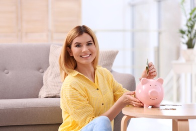 Woman with piggy bank and money at home