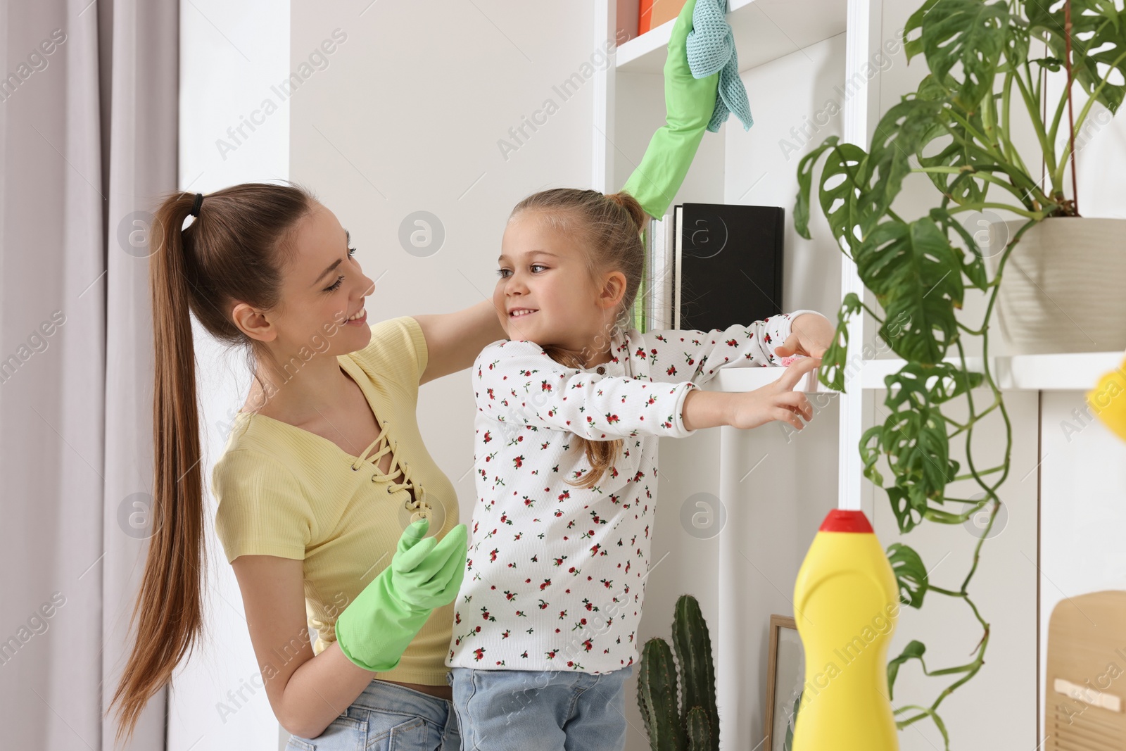 Photo of Spring cleaning. Mother and daughter tidying up together at home