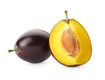 Whole and cut ripe plums on white background