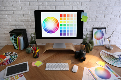 Photo of Modern computer and office supplies on wooden table. Designer's workplace