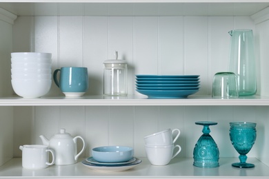 Photo of White shelving unit with set of dishware