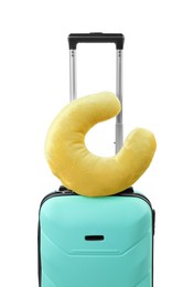 Photo of Soft travel pillow on turquoise suitcase isolated on white