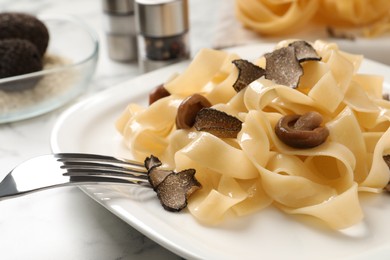 Tasty tagliatelle with truffle on table, closeup