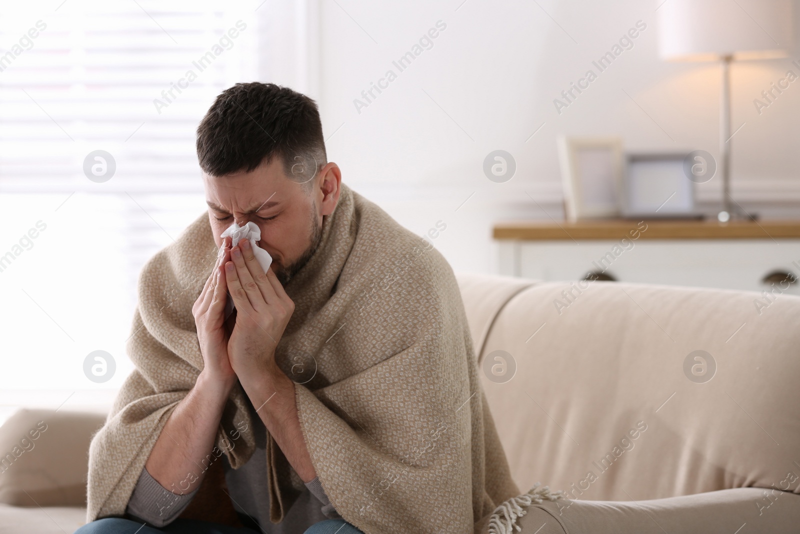 Photo of Man suffering from runny nose at home