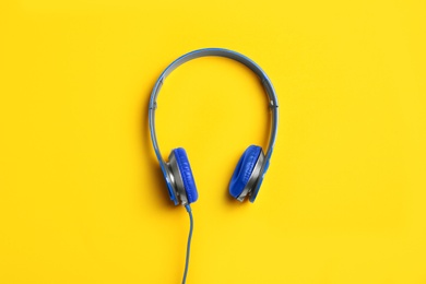 Photo of Stylish headphones on color background, top view